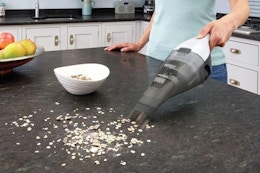 a woman using a black+decker vacuum