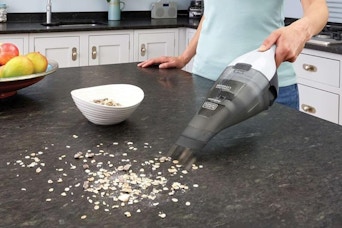a woman using a black+decker vacuum