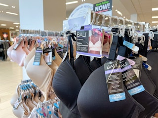 A variety of Bali bras hanging on a store rack.