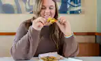 a person sitting in taco bell with a mexican pizza