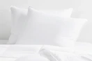 two queen pillows in white bedding