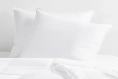 two queen pillows in white bedding
