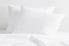 two queen pillows in white bedding