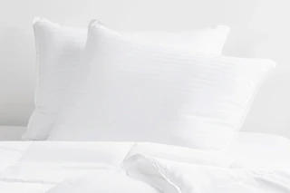 two queen pillows in white bedding