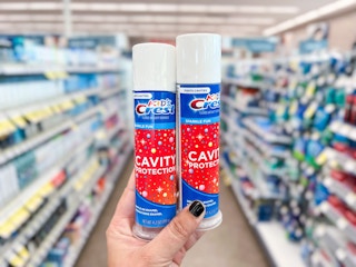 hand holding two tubes of toothpaste