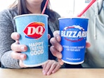 two people holding dairy queen summer blizzards 