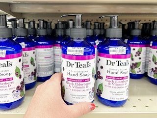person grabbing dr teals hand soap off shelf in big lots