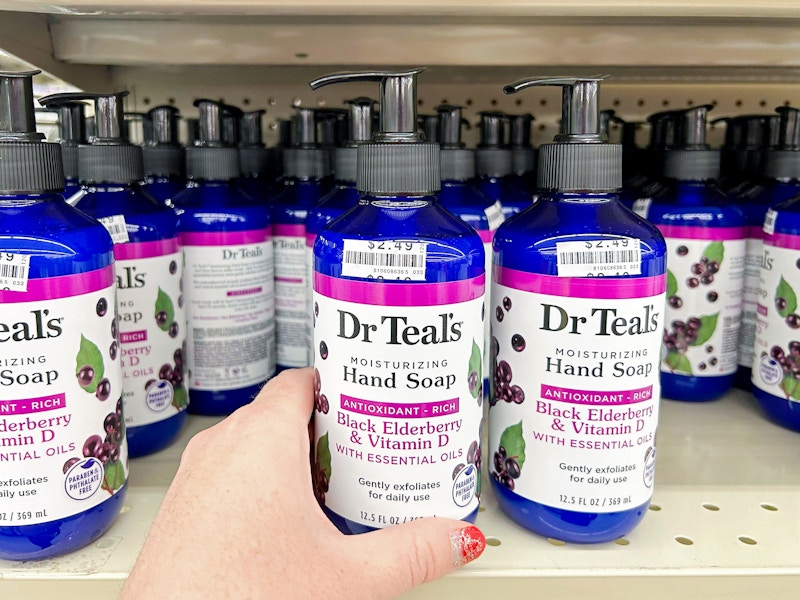 person grabbing dr teals hand soap off shelf in big lots