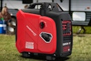 gas generator on the grass in front of an RV camper