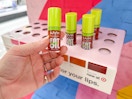 Someone picking out a shade of Nyx Fat Lip Drip Oil