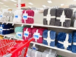target cart parked in front of bed blankets sitting on a shelf