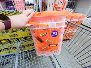 hand balancing a bucket of 375 reeses's in a cart