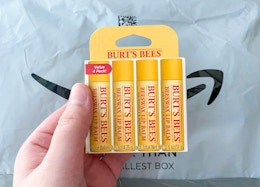 a hand holding a pack of lip balm