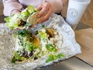 someone picking up a taco