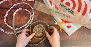Someone weaving a basket out of braided strips of plastic grocery bags
