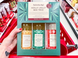 A Holly Jolly Mix Trio held out in front of a store cart in the middle of a store aisle.