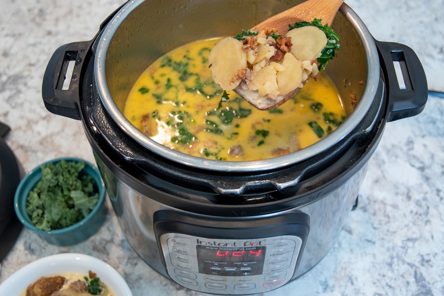 A person ladling soup out of an instant pot