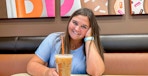 a person smiling with coffee inside of dunkin