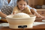 a little girl and parent making bread in a sourdough starter