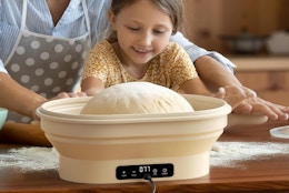a little girl and parent making bread in a sourdough starter