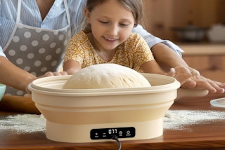 a little girl and parent making bread in a sourdough starter