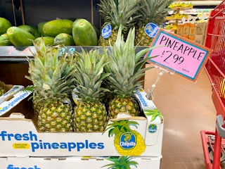 fresh pineapples with price sign in trader joes