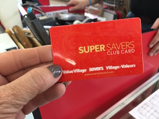A person holding a Super Savers card in a Value Village thrift store