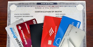 A death certificate with some credit cards on top of it