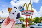 someone holding a squishmallow happy meal toy outside of mcdonalds