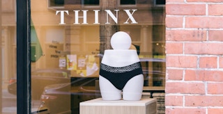 A pair of Thinx underwear in a shop window with the brand's decal on the window