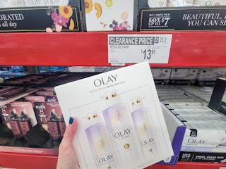 hand holding a 3-pack of olay body wash with retinol