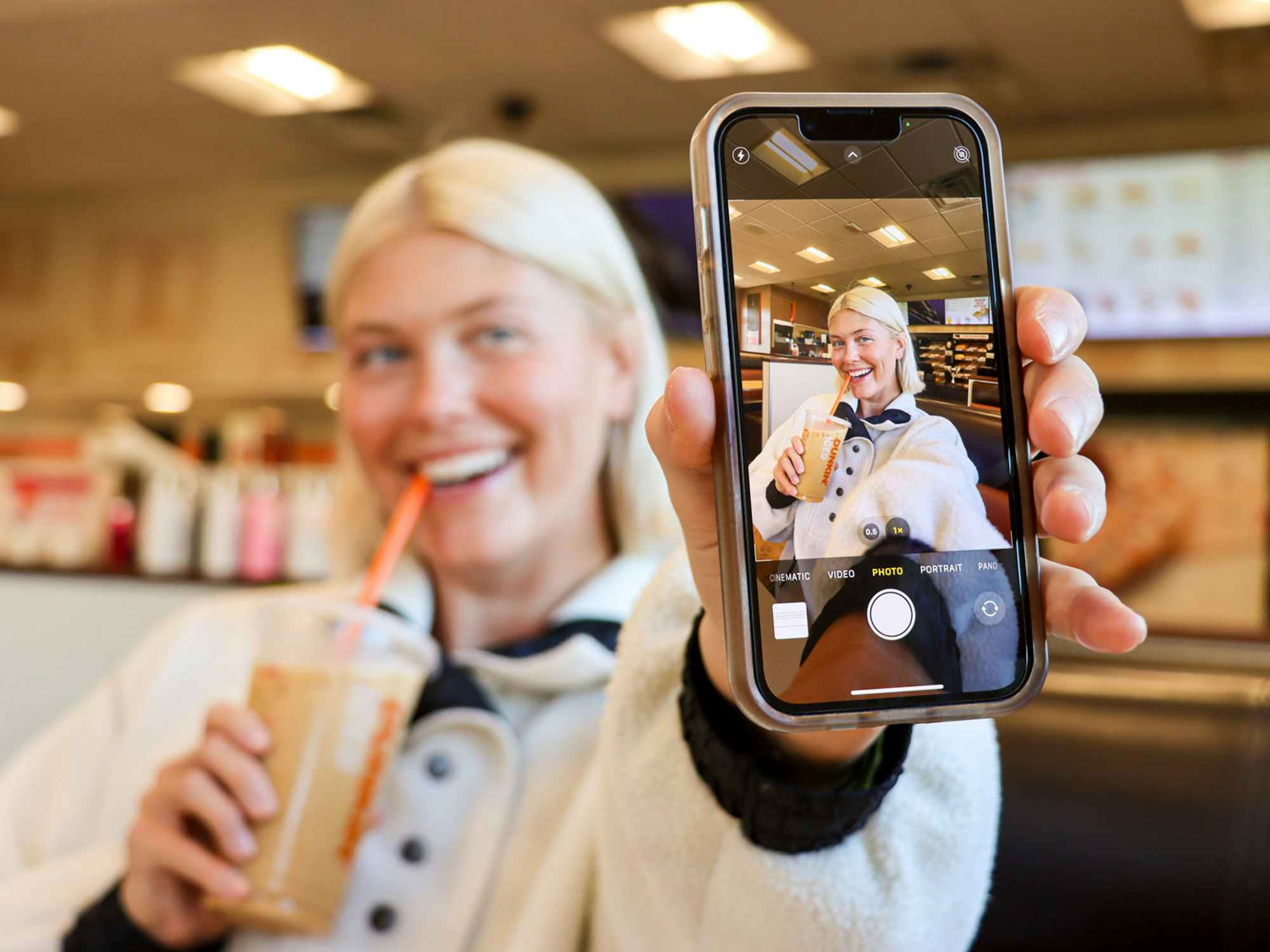 a person taking a photo at dunkin donuts