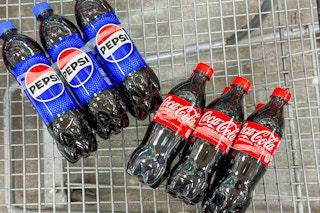pepsi and coca cola soda in shopping cart