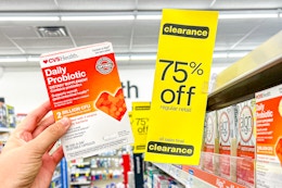 someone holding up a CVSHealth product next to a clearance sign at CVS