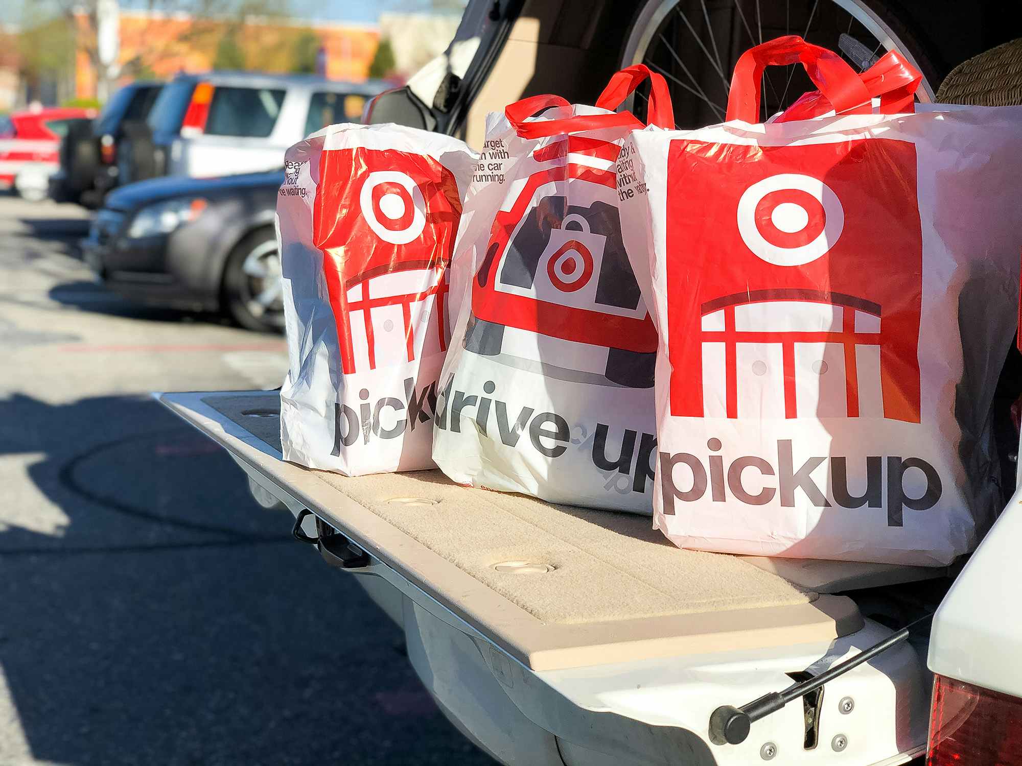 Target drive up and pickup bags full of items sitting in the trunk of a car with the door open