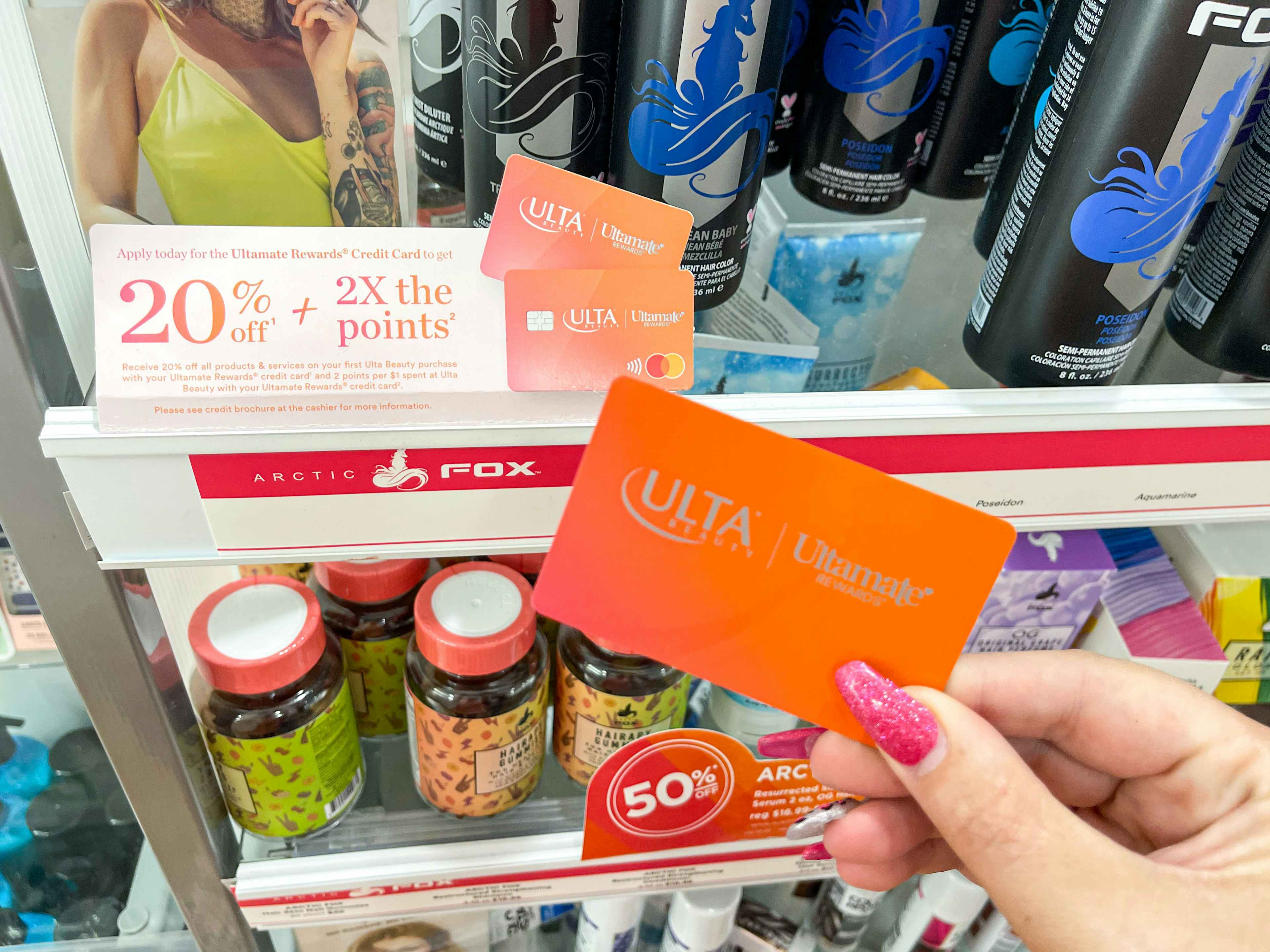 a person holding a credit card in store in front of rewards signage 