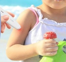 a hand holding an insect bite relief device on a child's arm