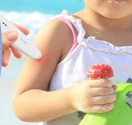 a hand holding an insect bite relief device on a child's arm
