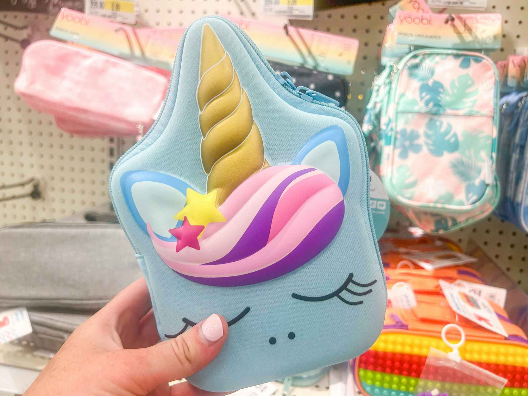 Someone holding up a Unicorn pencil case at Target