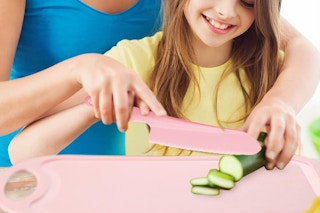 Parent helping child cut food