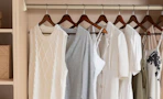 clothes on wooden hangers in a closet