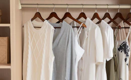 clothes on wooden hangers in a closet