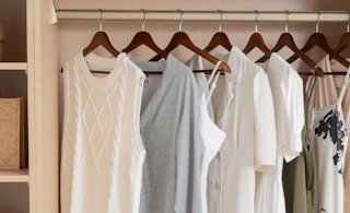 clothes on wooden hangers in a closet