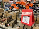 Two tables stacked with shoe boxes and a Clearance sign with information about the prices and clearance colors.