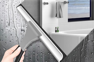 a woman using a shower squeegee