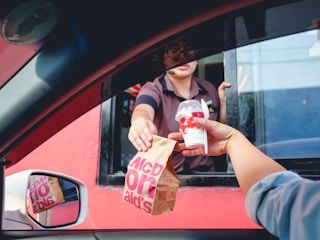 mcdonalds drive-thru employee handing driver food through window