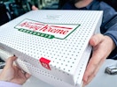 Person recieving a box of krispy Kreme Donuts