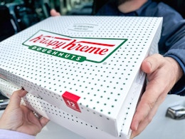 Person recieving a box of krispy Kreme Donuts