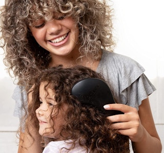 a mom brushing a daughter's hair