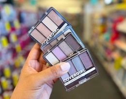hand holding four Covergirl eyeshadows